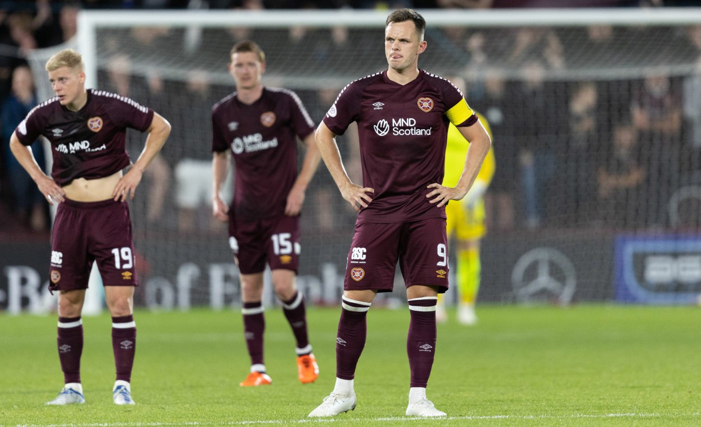 Hearts' Lawrence Shankland looking dejected on the pitch with two other players behind him
