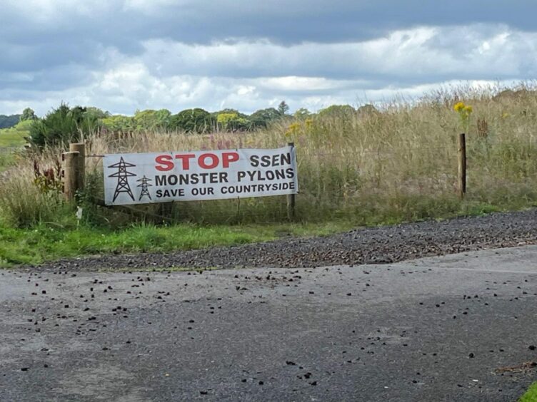 'Stop SSEN Monster Pylons' sign in countryside.
