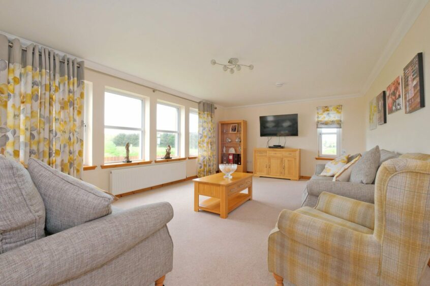Spacious lounge with large windows with views of the Aberdeenshire countryside.