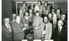 Charles Matheson, front, second left, chairman of the RUA Club, presents the Bill  Baxter Dominoes Pairs trophy to Walter Baxter and Gordon Harrison, watched by  other members of the club at their annual presentation of prizes. Image: DC Thomson