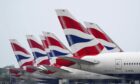 British Airways planes lined up with a view of the tails.