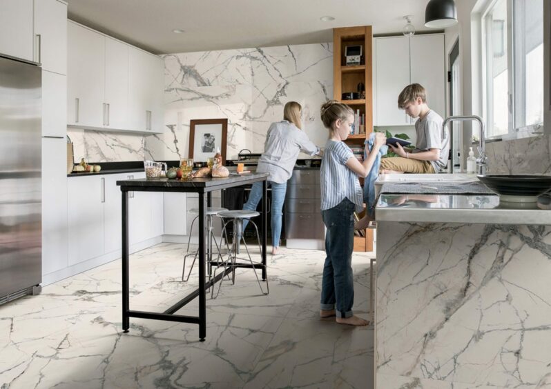 two children with their mother in their kitchen featuring beautiful marble tiles 