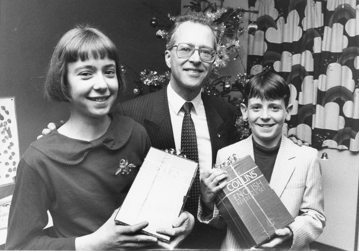 Graeme Munro, a member of the Friends of Danestone Primary School Award Trust, presents Emily Hesp and Andrew Pearson with awards for being the pupils who worked hardest in primary school work for the year 1989-90.