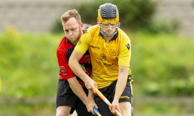 Fort William's Johnny Forster keeps the ball from Daniel Mackintosh, of Glenurquhart. Image: Neil G Paterson.