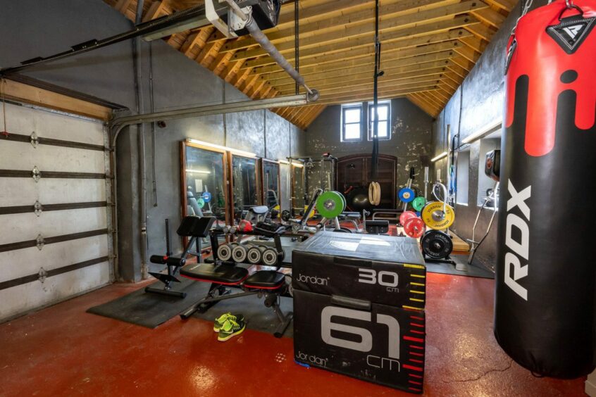 The impressive gym in the property, with weights, a punching bag and more