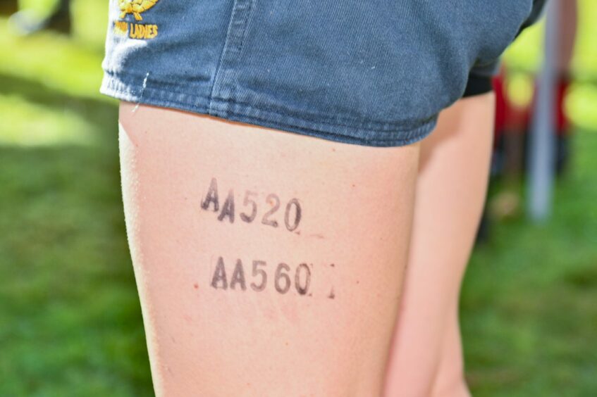 A competitor has her competition numbers stamped on her leg.