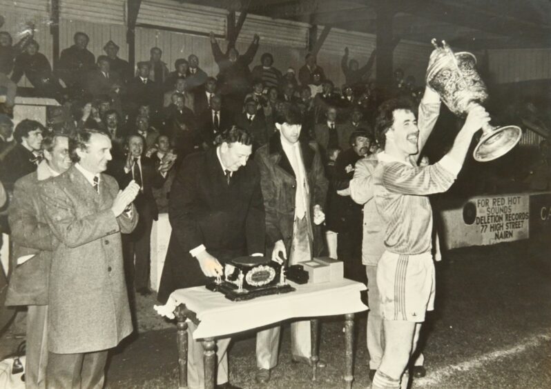 Peter Corbett lifting the 1983 Qualifying Cup (North) Trophy in front of crowds