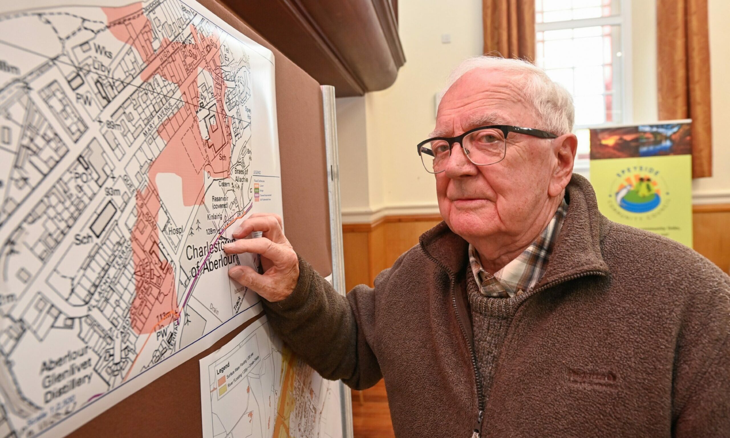 Bill Robertson points to a map of Aberlour during the flooding meeting. 