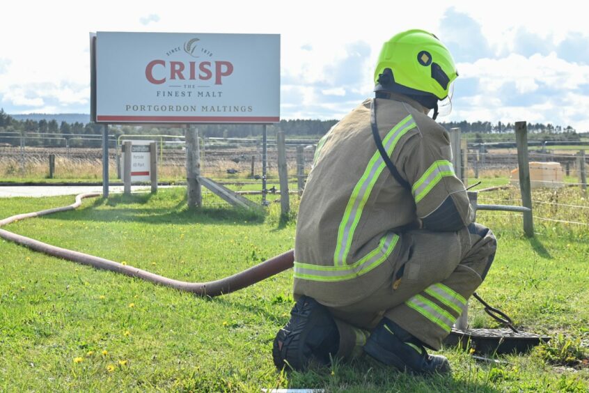 A firefighter pictured next to the Crisp Portgordon Maltings entrance sign