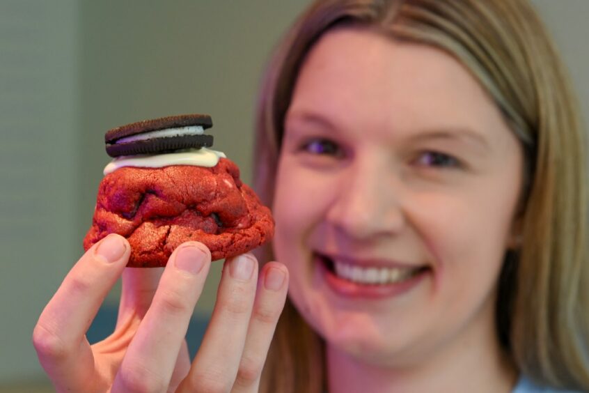 Amanda with a freshly-made red cookie with an Oreo on top