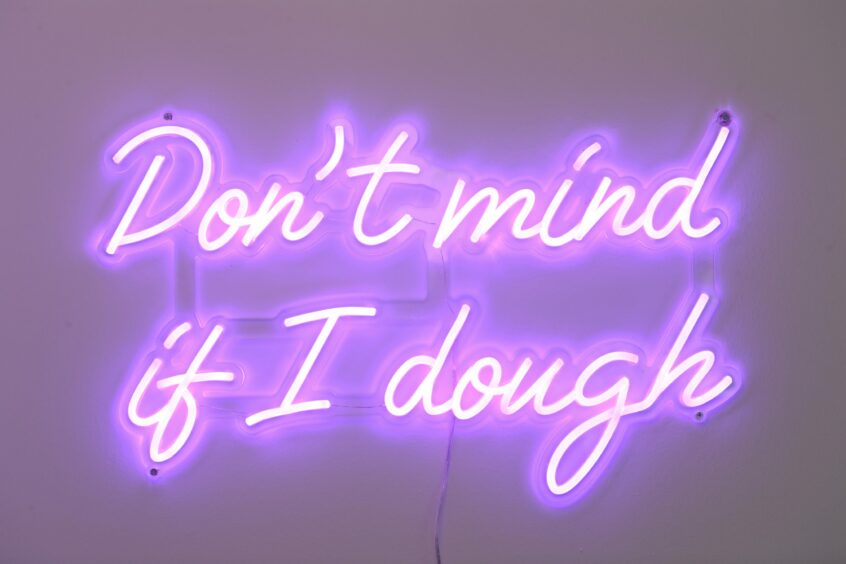 A purple neon sign reading 'Don't mind if I dough'