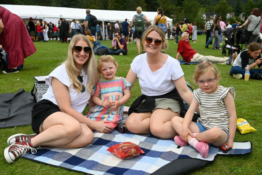 A family sitting on a picnic blanket at Ballater Highland Games 2023