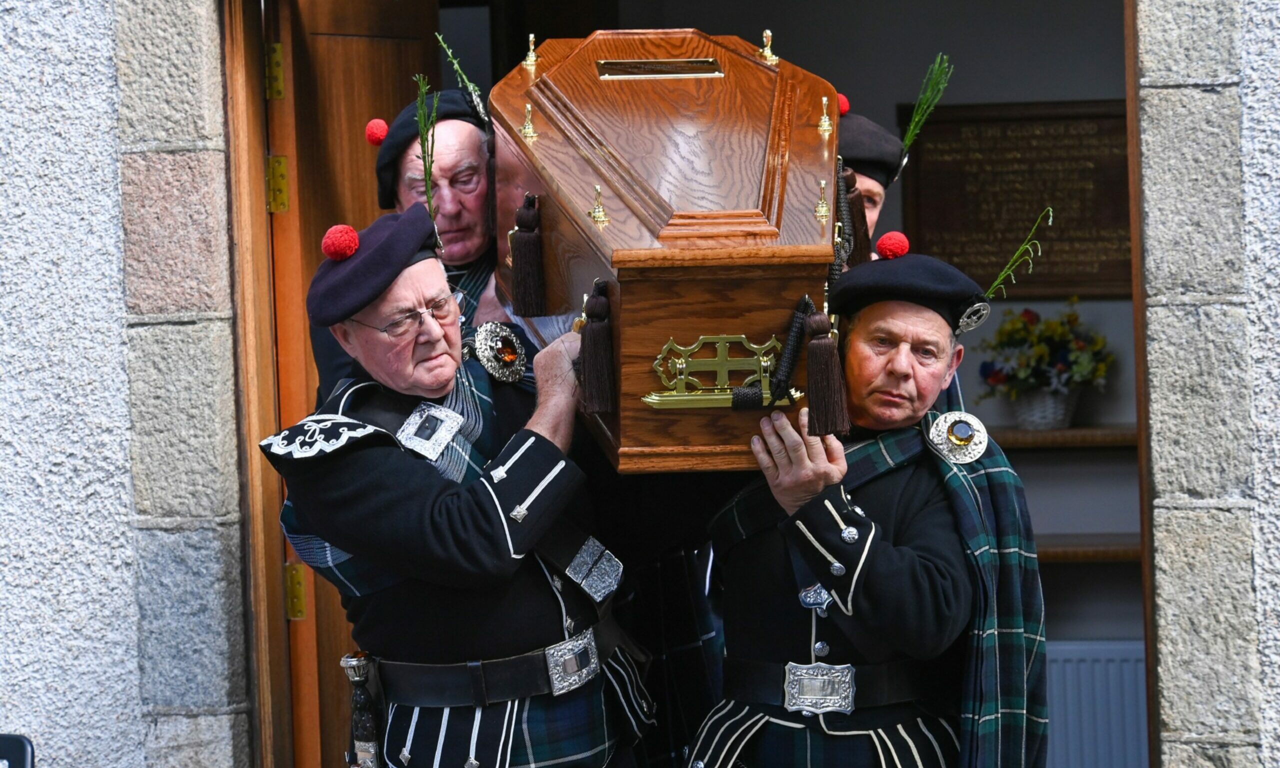 Highlanders carrying the coffin at Robbie Shepherd's funeral. 