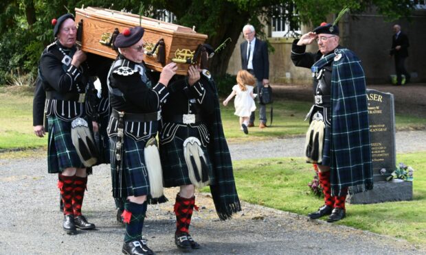 The Lonach Highlanders carrying the coffin at the funeral of Robbie Shepherd.