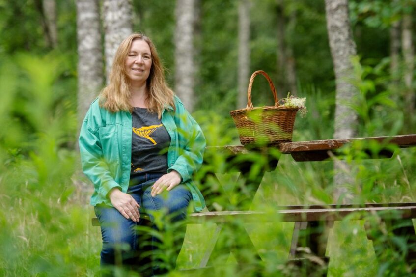 Leanne with a basket of plants and mushrooms foraged in Aberdeenshire.