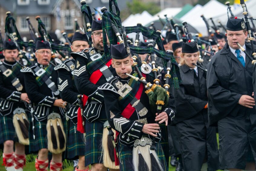 Pipers perform to crowds of people at the Aboyne Highland Games. 