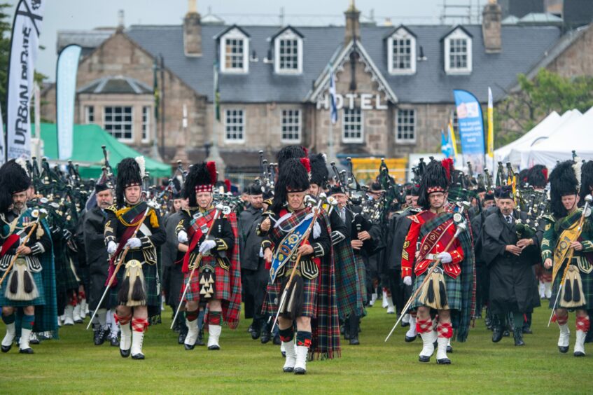 Five pipe bands - in full Scottish regalia - line up to play at Aboyne Highland Games