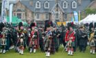 Five pipe bands - in full Scottish regalia - line up to play at Aboyne Highland Games