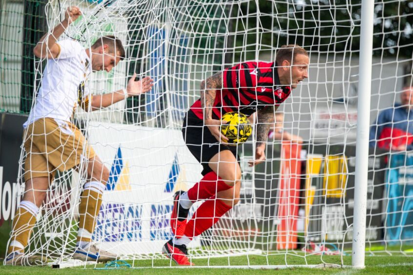 Jonny Smith of Inverurie gathers the ball out of the net after Callum Duncan scored their second goal against Huntly.