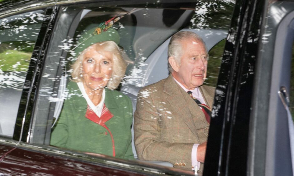 Charles and Camilla in car arriving at Crathie Kirk