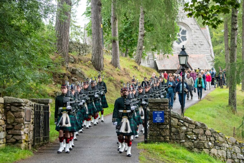 The Kings Guard leave Crathie Kirk followed by the crowds after the service.