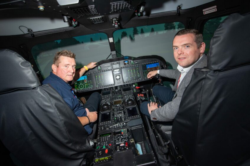 Douglas Ross at the controls of the search and rescue helicopter simulator with pilot Johan Arjis.