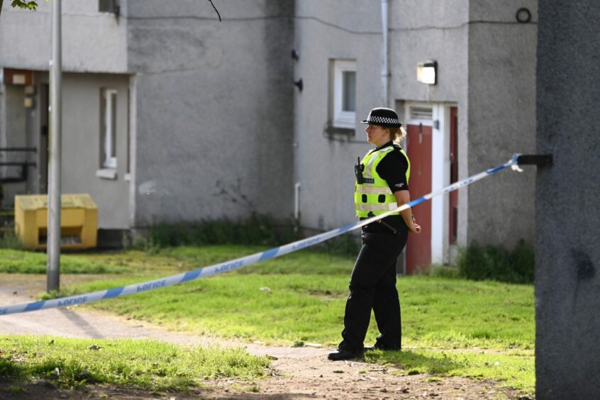 Police officer guards the cordoned property at Seaton Walk, Aberdeen, where the death occurred.