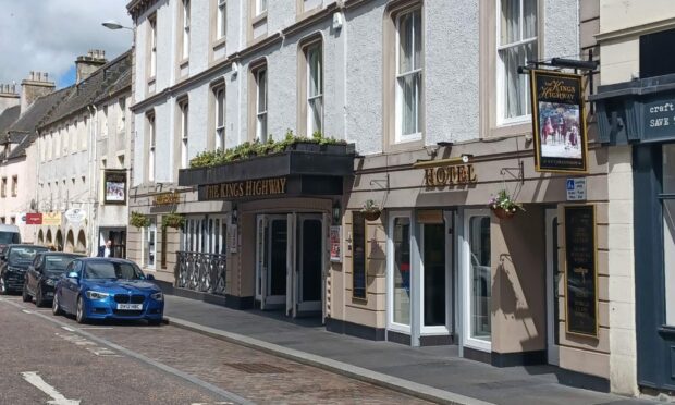 A city centre pub with a hanging sign that reads "The King's Highway"