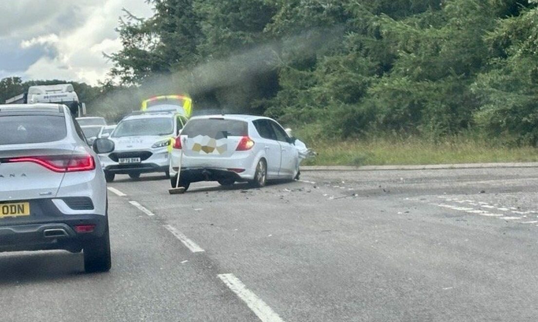 White car with damage to front blocking A96. 