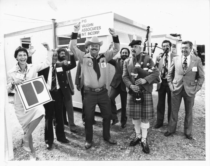 4 September 1979: Texan version of the Highland fling by Mr Bobby Sparkman (centre) of Edessa, in the cowboy state. Pipe Major Jim Christie of Grampian Police Pipe Band provides the music while Mrs Peter Jones (left) of Premier Offshore Engineering Contractors enters into the fun of attracting visitors to  Offshore Europe.