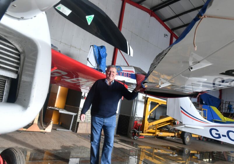 Don Jack standing next to some small planes