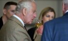 King Charles sniffs a glass of whisky