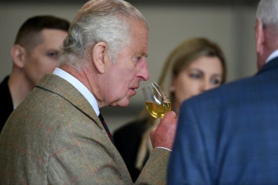 King Charles sniffs a glass of whisky