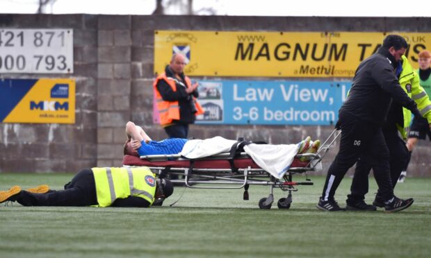 Peterhead's Conner Duthie pictured being stretchered off after sustaining a knee injury in a match against East Fife.