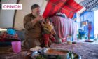 Widower Khalil feeds his daughter inside a tent in north-west Syria. The family lost their home due to earthquake damage (Image: Arete/DEC)