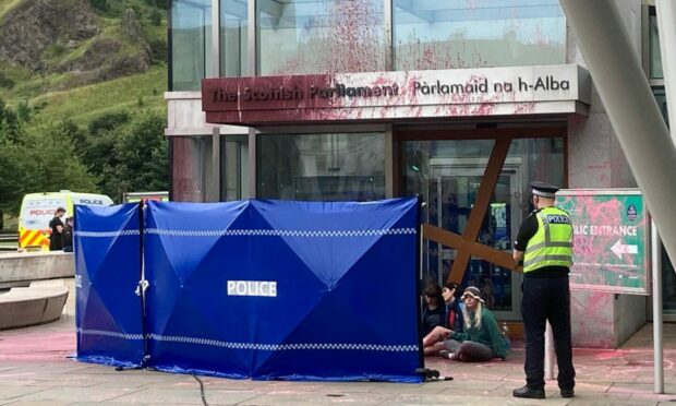 Anti-oil protesters have covered the parliament building in red paint. Image: DC Thomson.