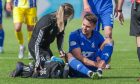 Cove Rangers defender Josh Kerr receives treatment after injuring his ankle in a match at Balmoral Stadium.