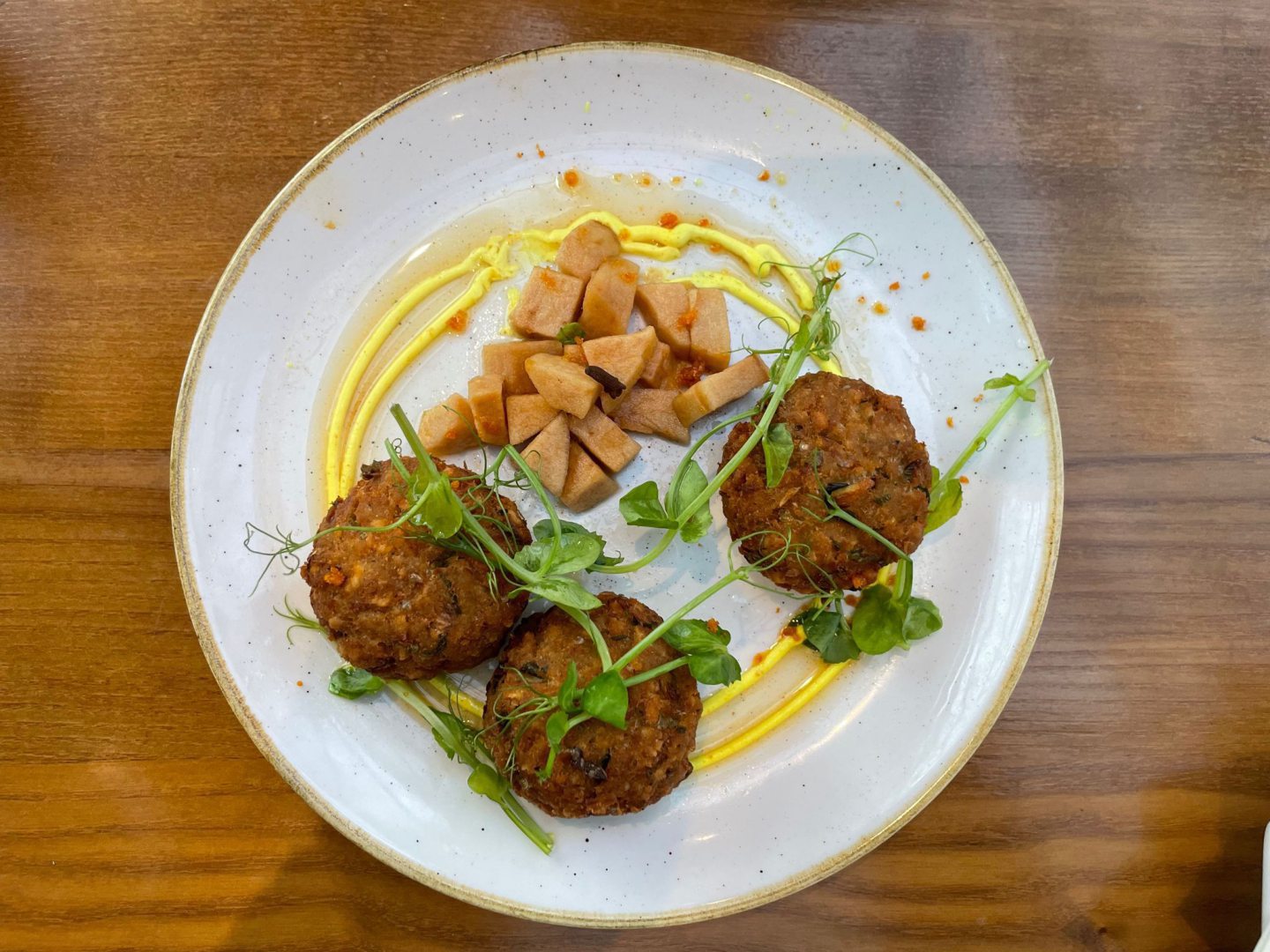 Three crab cakes with chopped pickled apple and a drizzle of lemon mayonnaise 