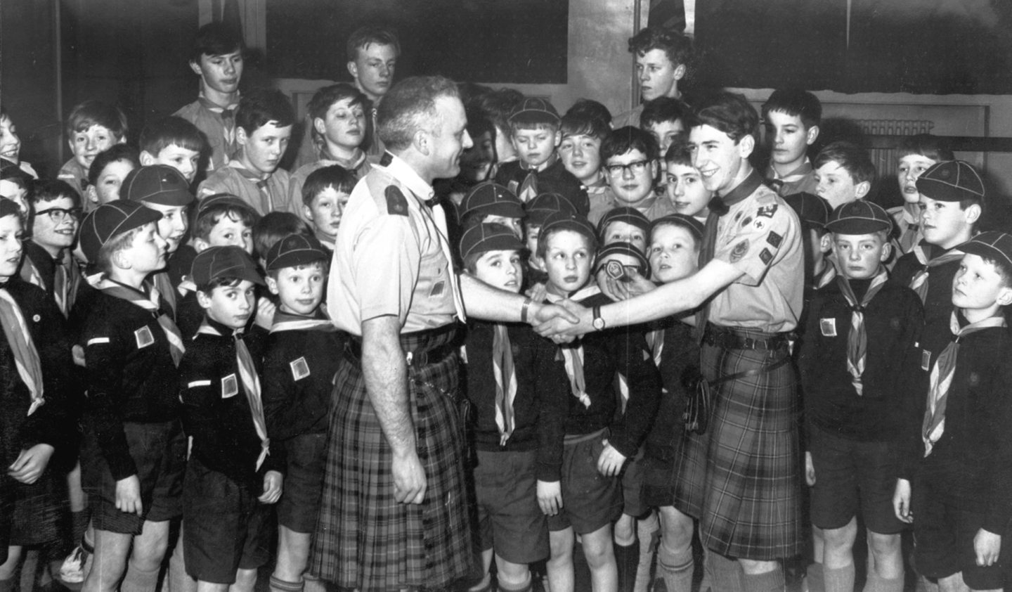 Patrol Leader Roderick Strachan of the 1st Grammar School Troop, Boy Scouts, received his Queen's Badge from Assistant District Commissioner D Hendry at a joint ceremony with the 10th Holburn Central Troop at the McClymont Hall, Holburn Street in 1967.