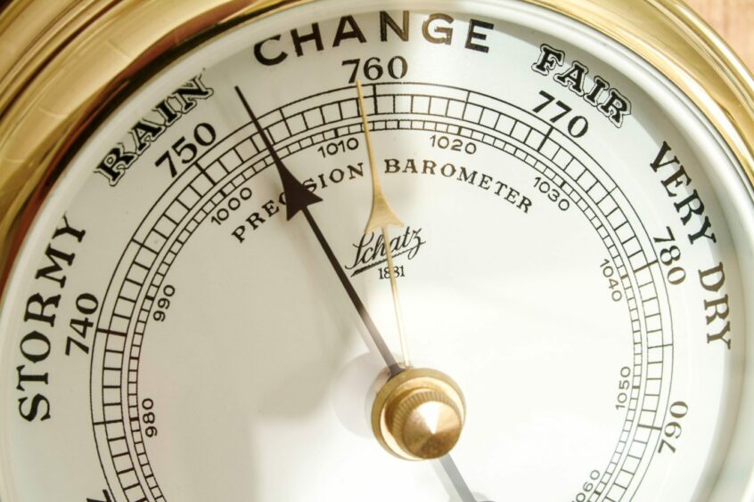 A barometer hanging on a wall.