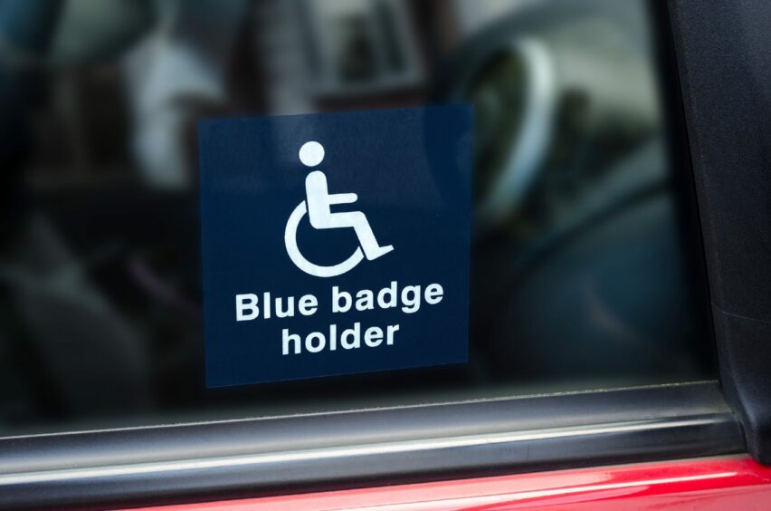 A blue badge holder sticker on a car window