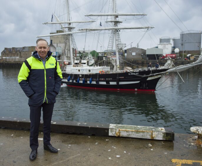 Mr Brebner with Sea Cadets' ship TS Royalist behind him during its visit to Peterhead in 2021.