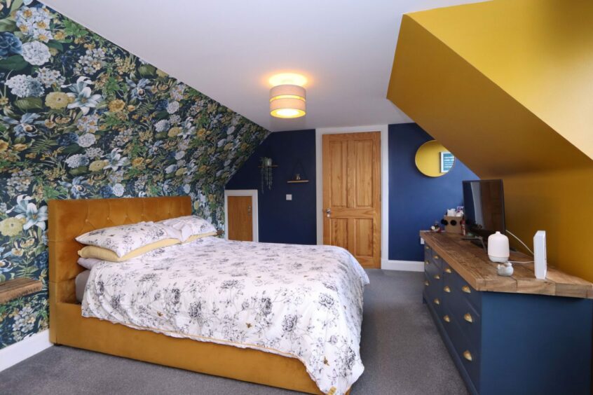 One of the bedrooms, with walls to match the living room, a double bed and a large dresser