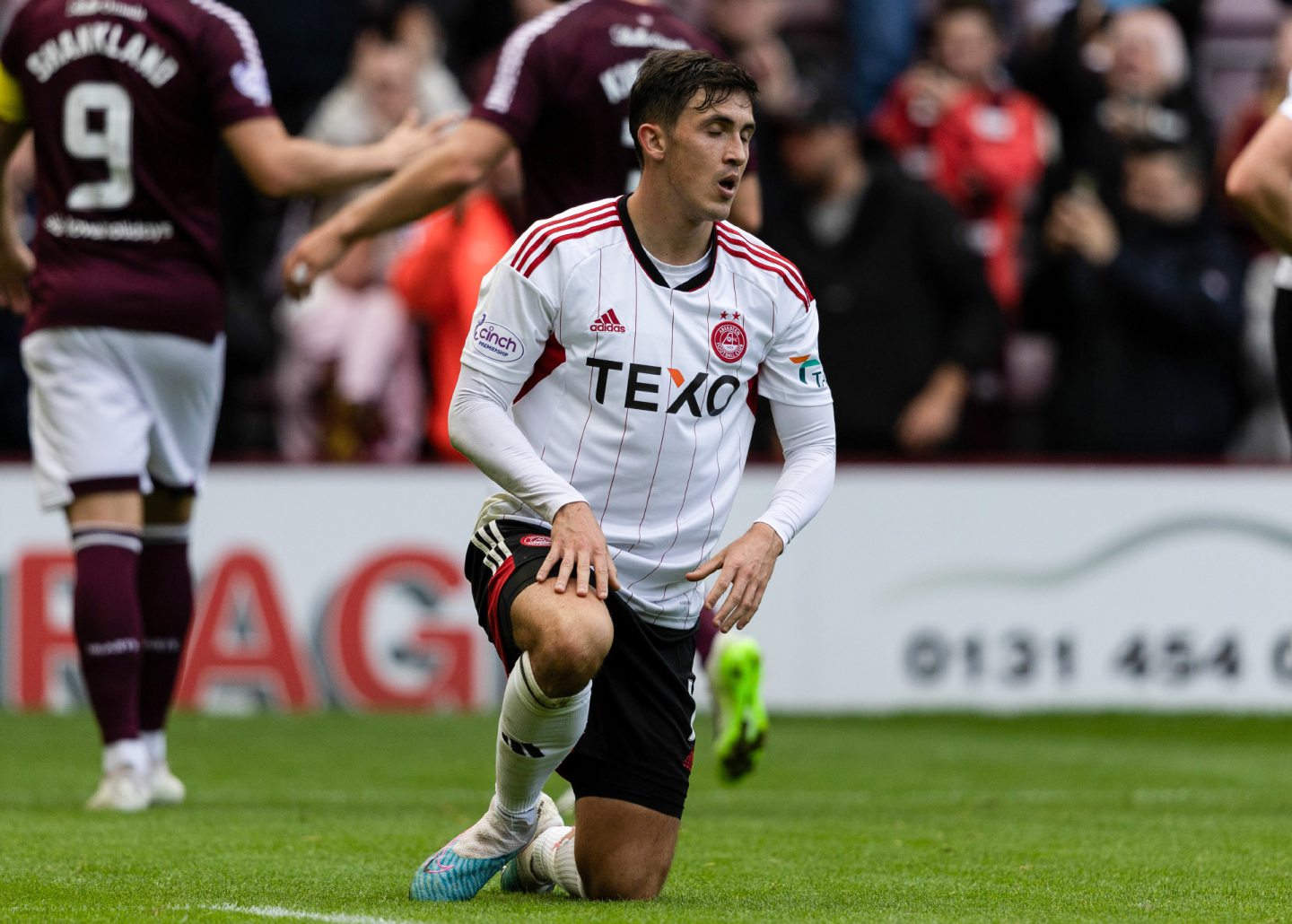 Aberdeen's Jamie McGrath looking dejected on one knee on the pitch