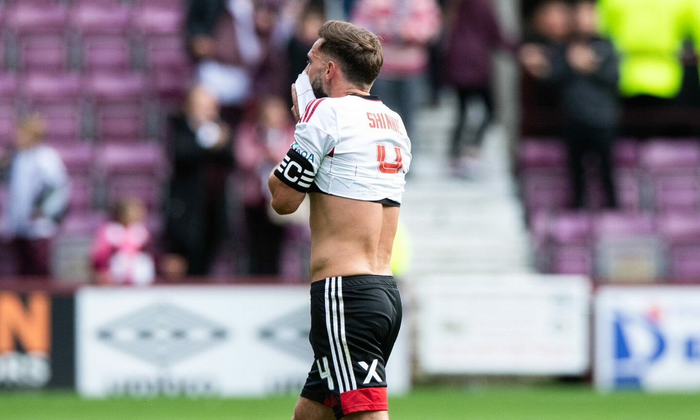 Aberdeen captain Graeme Shinnie wiping his face with the hem of his shirt