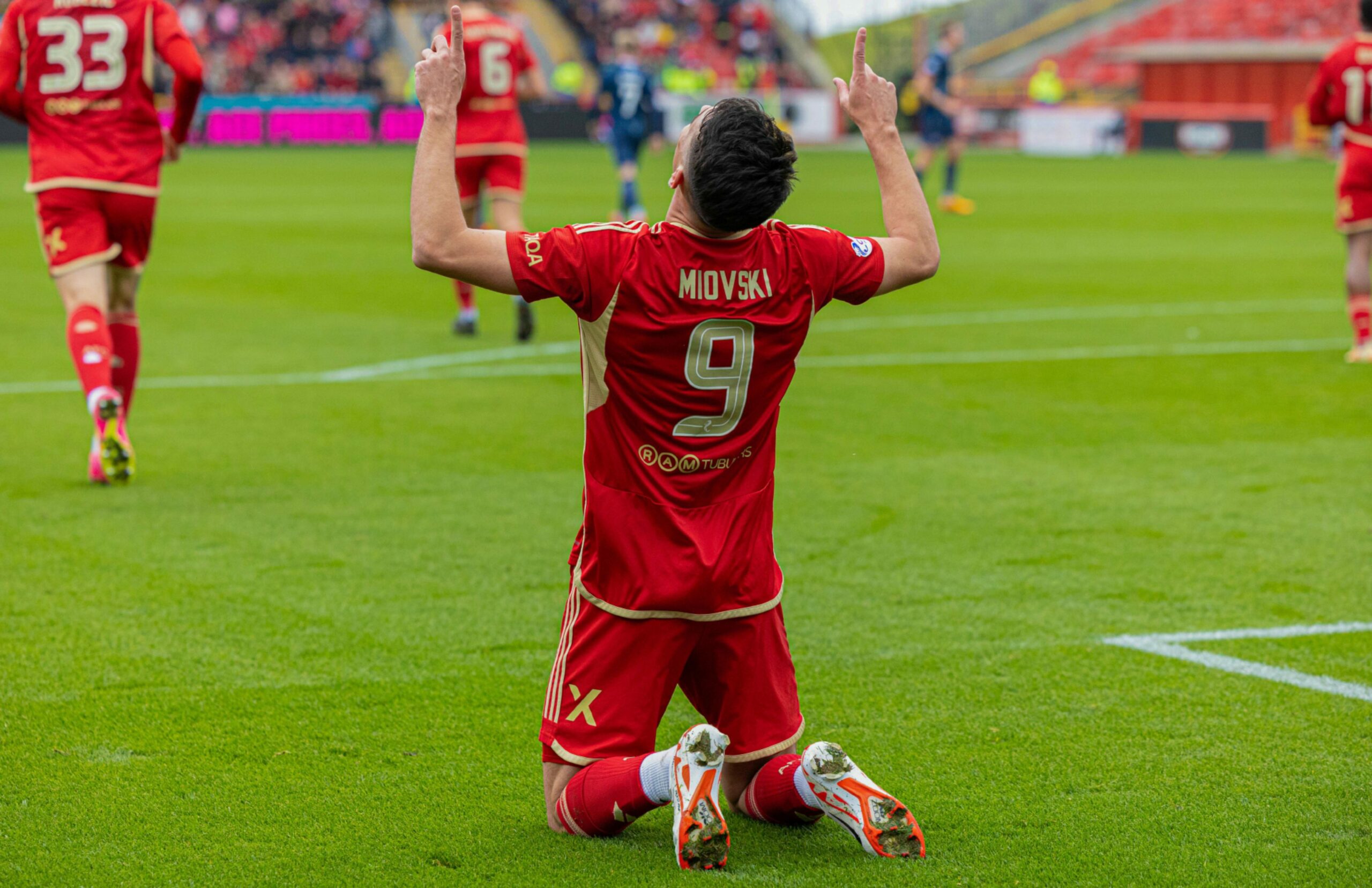 Aberdeen's Bojan Miovski on his knees with his fingers pointing to the sky