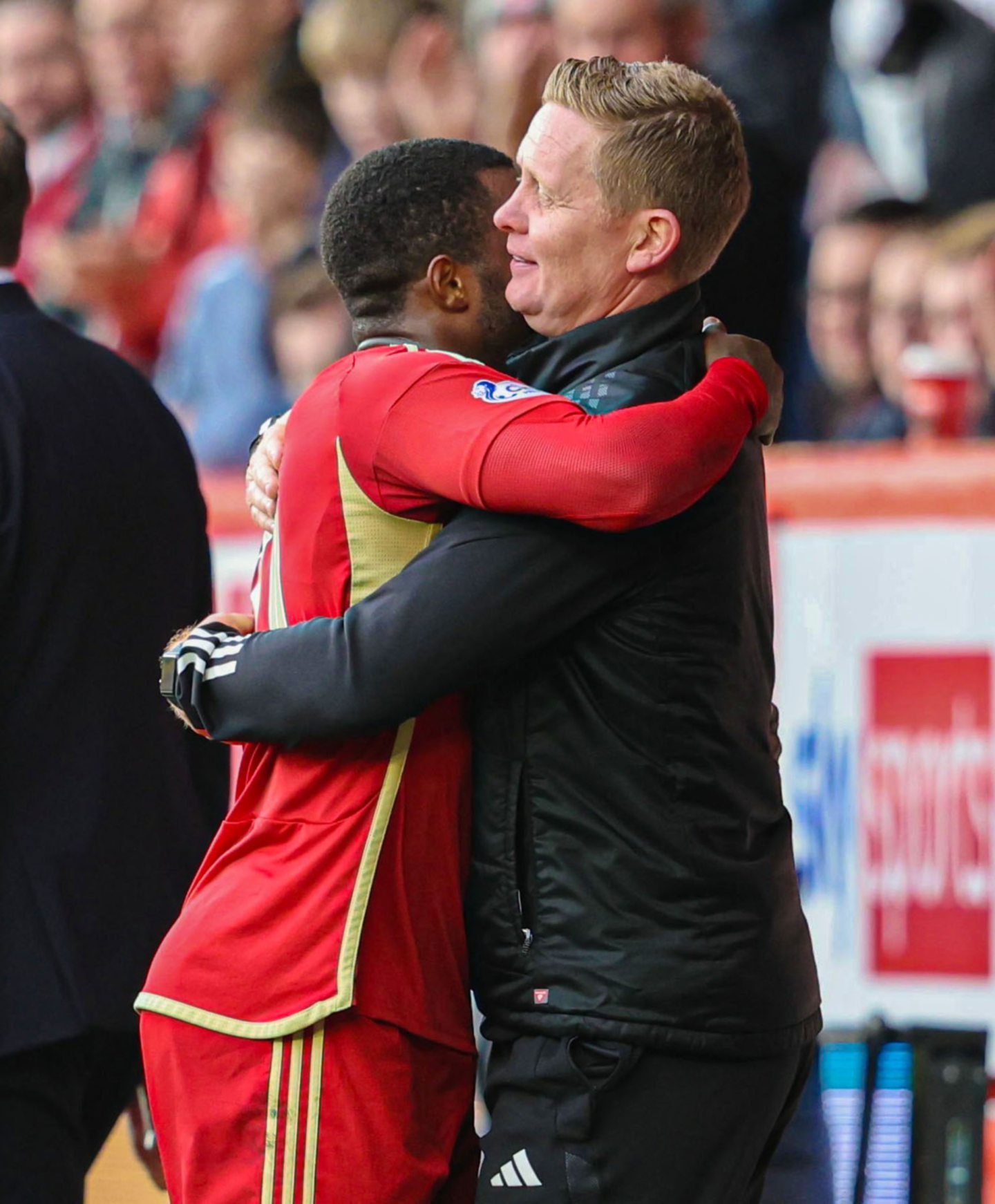 Dons manager Barry Robson embraces Duk as he is subbed off against the Staggies.
