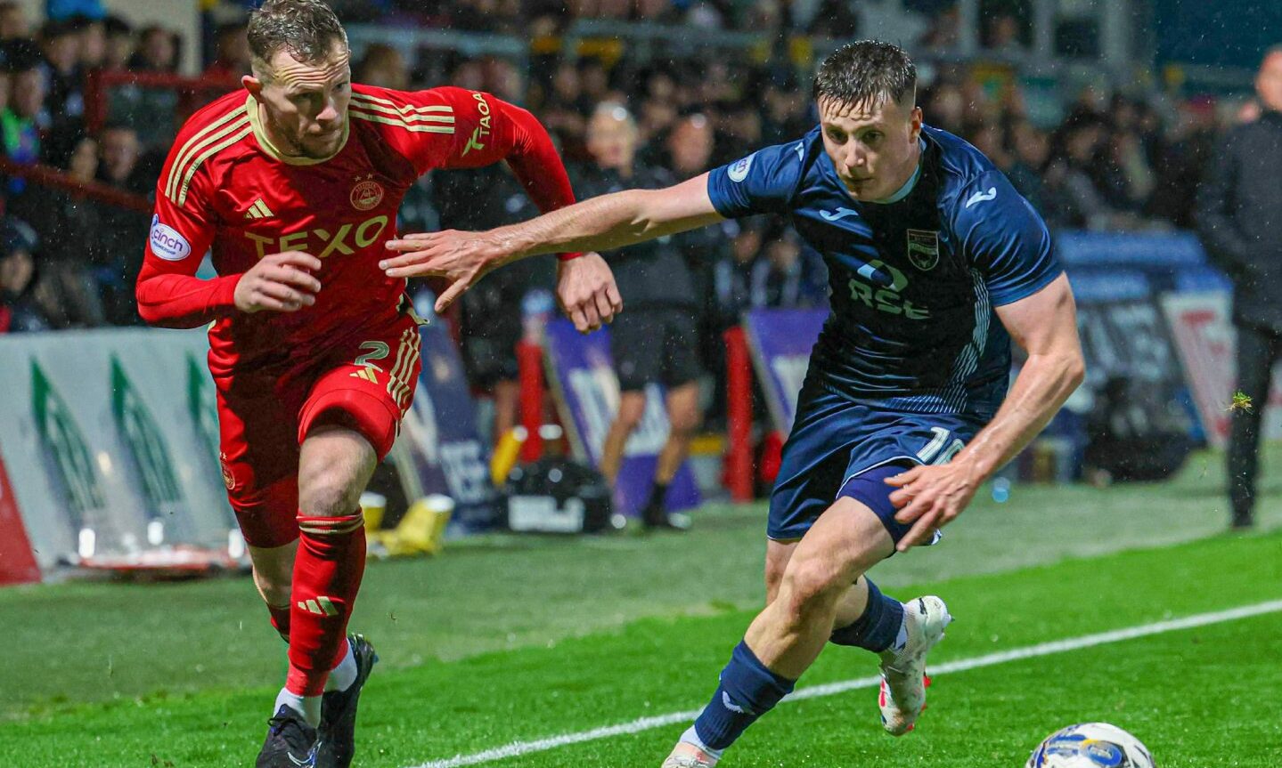 Aberdeen's Nicky Devlin chasing the ball, with a ross county player beside him