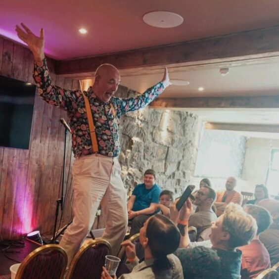 Attendees take photos as the Aberdeen comedian performs on stage.