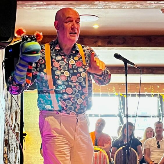 Sid with a colourful puppet as part of his comedy act.